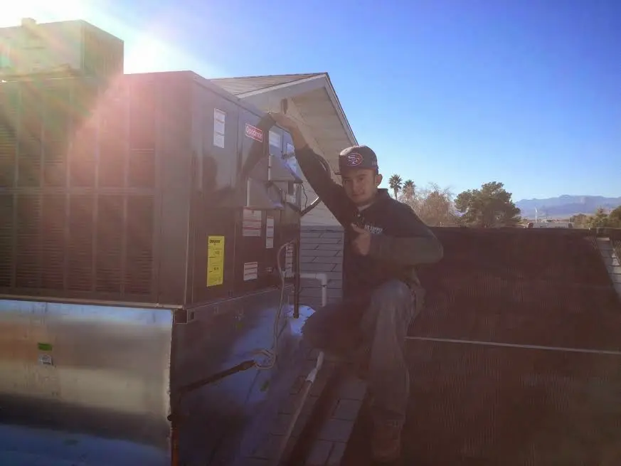 HVAC technician performing Air Duct Repair on a rooftop unit in Prairie Ridge