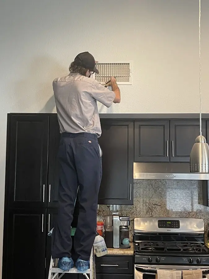 Technician inspecting an air vent during HVAC service in Prairie Ridge